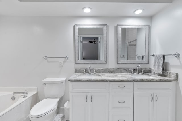 full bath featuring toilet, a garden tub, double vanity, and a sink