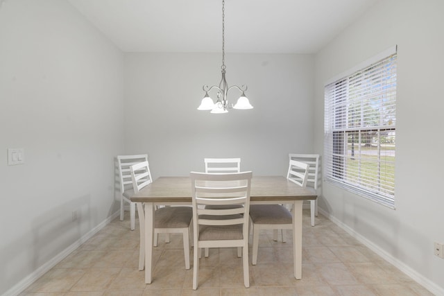 dining space featuring a chandelier, light tile patterned floors, and baseboards