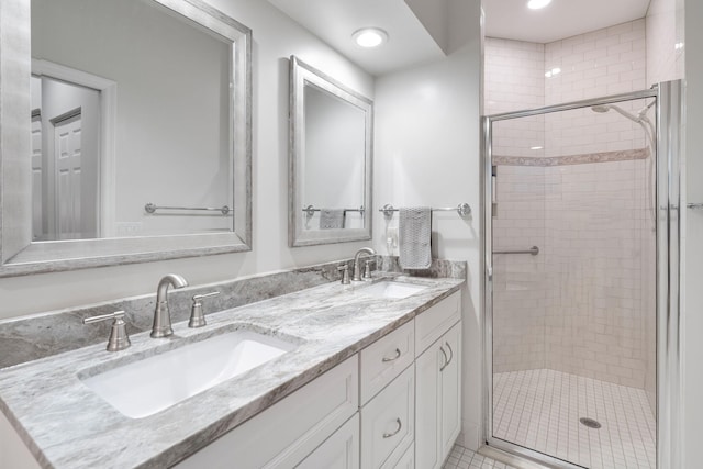 full bath with a shower stall, double vanity, and a sink