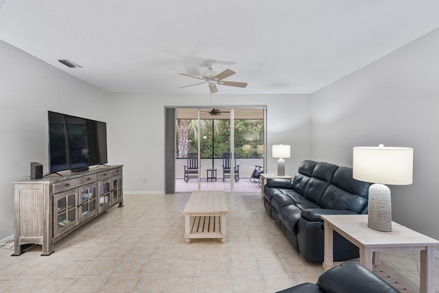 living area featuring light tile patterned floors, visible vents, baseboards, and a ceiling fan