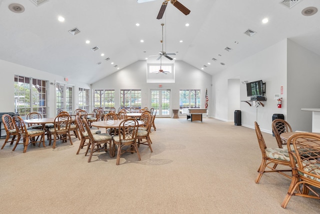 dining area with high vaulted ceiling, visible vents, and light colored carpet
