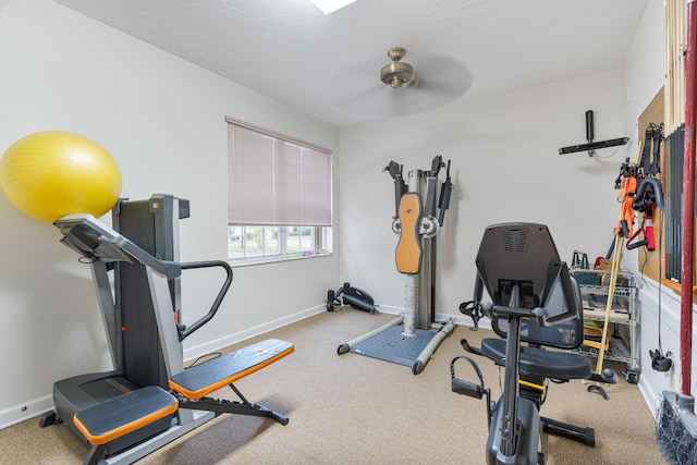 exercise area featuring baseboards, a ceiling fan, and carpet