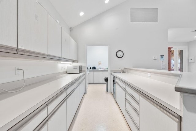 kitchen featuring a sink, visible vents, light countertops, and high vaulted ceiling