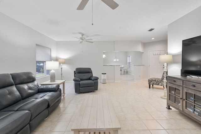 living area with visible vents, a ceiling fan, and light tile patterned flooring