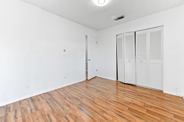 7000 NW 95th Ter, Tamarac, FL 33321 - unfurnished bedroom with a textured ceiling, visible vents, baseboards, and light wood-style floors