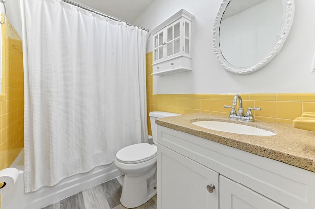 7000 NW 95th Ter, Tamarac, FL 33321 - full bathroom featuring vanity, wainscoting, toilet, tile walls, and shower / tub combo