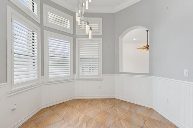 9600 Equus Cir, Boynton Beach, FL 33472 - unfurnished dining area featuring marble finish floors, arched walkways, crown molding, wainscoting, and a ceiling fan