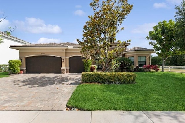 9600 Equus Cir, Boynton Beach, FL 33472 - view of front of house with an attached garage, a front yard, decorative driveway, and stucco siding