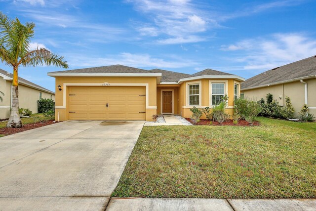 10771 SW Cremona Way, Port Saint Lucie, FL 34987 - view of front of house with stucco siding, a garage, driveway, and a front lawn