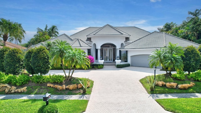17652 Lake Estates Dr, Boca Raton, FL 33496 - view of front of property featuring stucco siding, a tiled roof, decorative driveway, and a garage