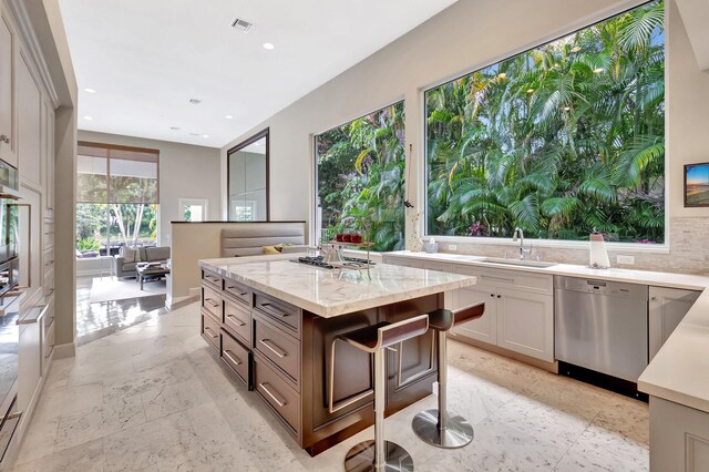 17652 Lake Estates Dr, Boca Raton, FL 33496 - kitchen featuring recessed lighting, stainless steel appliances, a sink, light stone countertops, and a center island