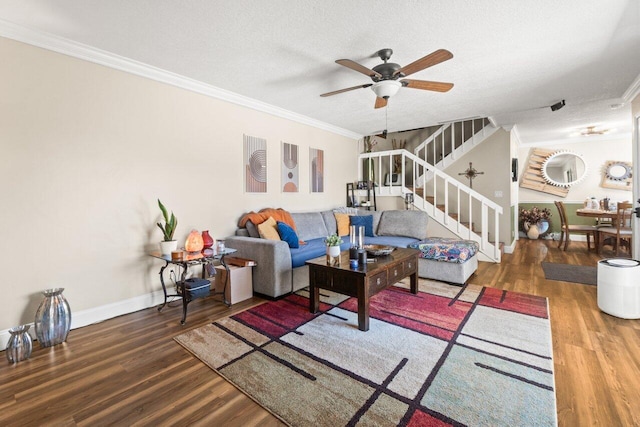 living room featuring stairway, baseboards, crown molding, and wood finished floors