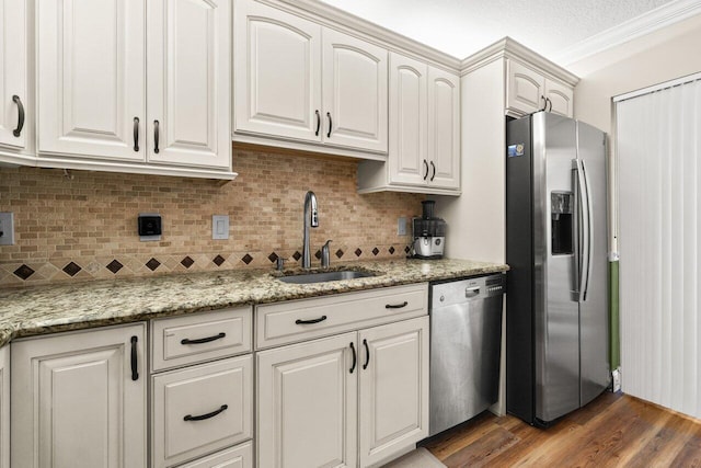 kitchen featuring a sink, tasteful backsplash, wood finished floors, and stainless steel appliances
