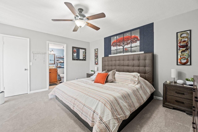 bedroom with ensuite bath, baseboards, ceiling fan, and light colored carpet