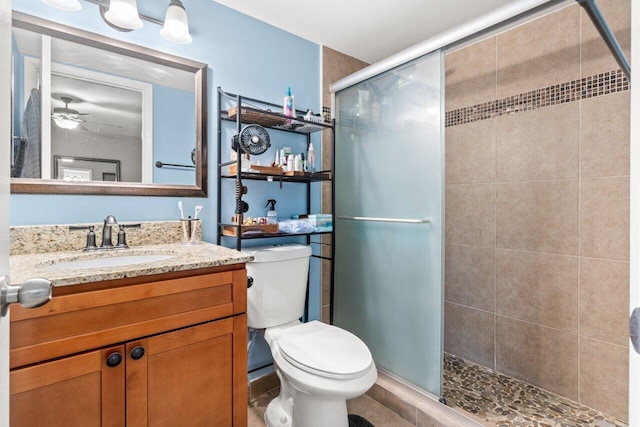 full bathroom with toilet, a stall shower, vanity, and a ceiling fan