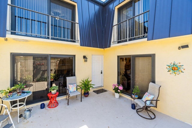 exterior space with a patio, stucco siding, and a balcony