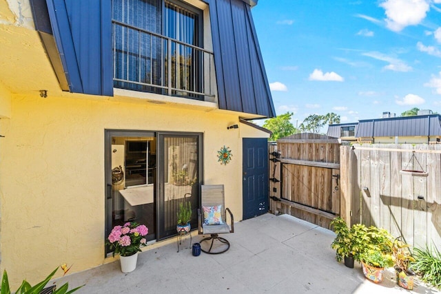 view of patio featuring fence and a gate