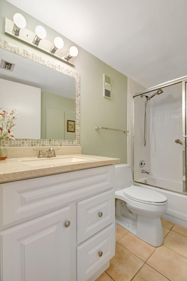 bathroom featuring tile patterned floors, visible vents, toilet, vanity, and bathtub / shower combination