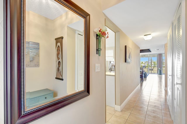 hallway with baseboards and light tile patterned floors