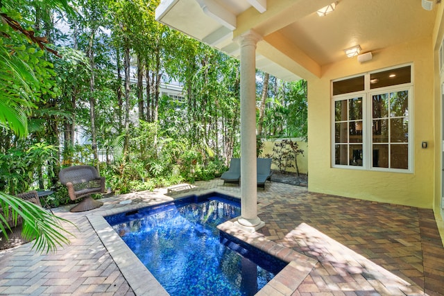 outdoor pool with fence and a patio area
