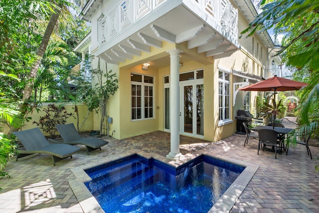 exterior space featuring a patio area, a fenced in pool, outdoor dining area, and area for grilling