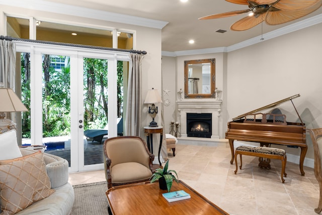 living area featuring visible vents, a ceiling fan, ornamental molding, french doors, and a lit fireplace