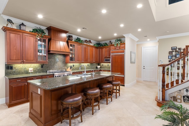 kitchen with crown molding, a sink, decorative backsplash, a kitchen bar, and baseboards