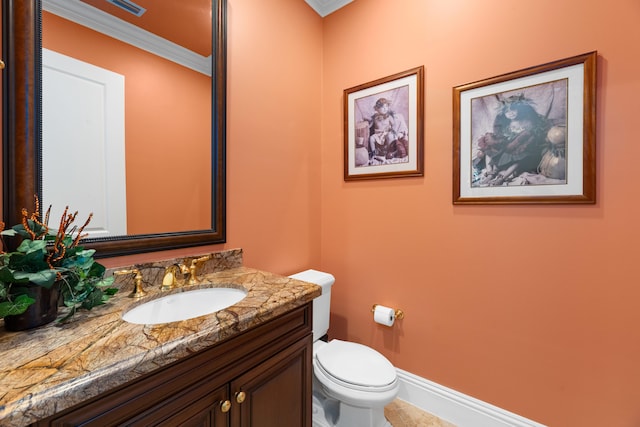 half bathroom with tile patterned floors, toilet, vanity, crown molding, and baseboards