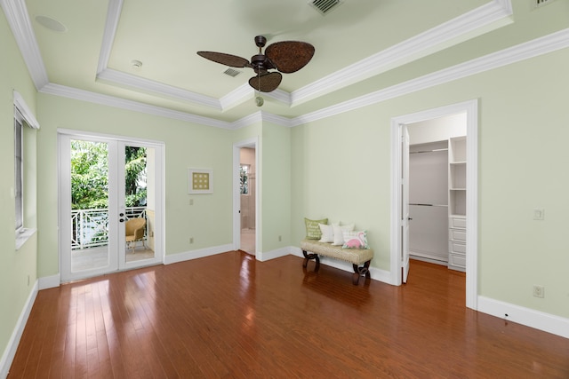 interior space featuring a tray ceiling, visible vents, a ceiling fan, hardwood / wood-style flooring, and ornamental molding