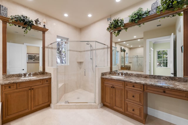 bathroom with two vanities, a sink, recessed lighting, and a stall shower