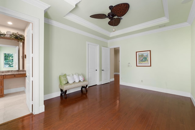 interior space featuring a raised ceiling, visible vents, baseboards, wood finished floors, and ornamental molding