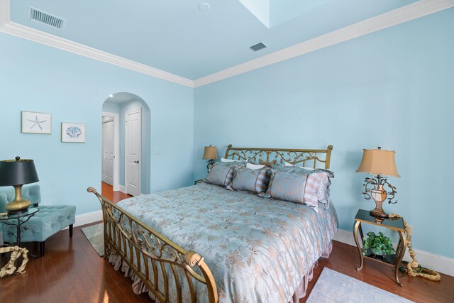 bedroom featuring arched walkways, visible vents, baseboards, and ornamental molding