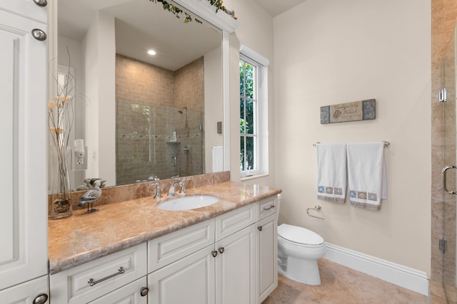 bathroom featuring a shower stall, tile patterned floors, vanity, baseboards, and toilet