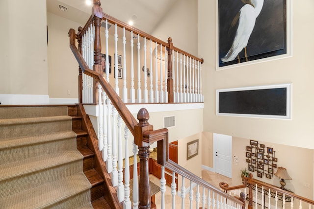 stairway featuring visible vents and baseboards