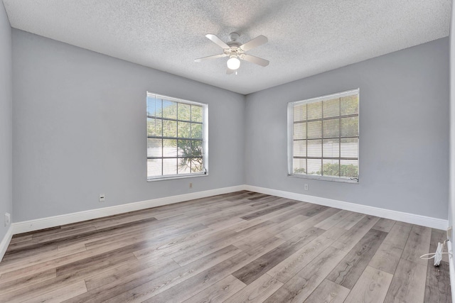 spare room featuring baseboards, a textured ceiling, wood finished floors, and ceiling fan