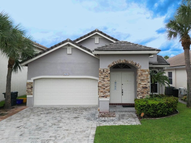 4091 Plumbago Pl, Lake Worth, FL 33462 - view of front of house featuring an attached garage, a tiled roof, stucco siding, and decorative driveway