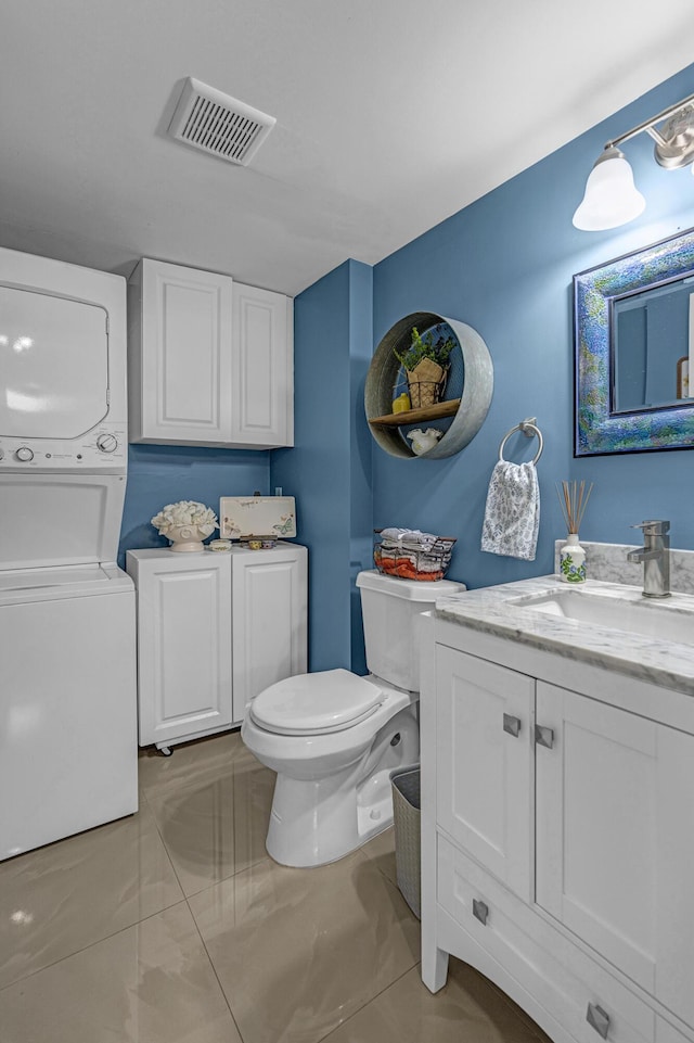 bathroom with visible vents, stacked washer / drying machine, vanity, toilet, and marble finish floor