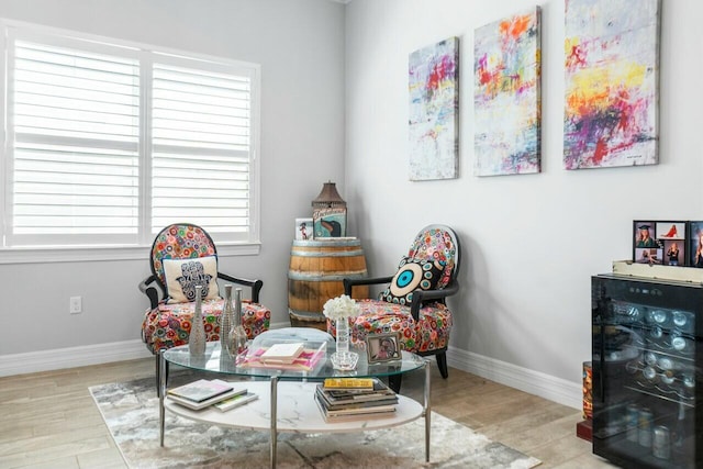 living area featuring baseboards, a healthy amount of sunlight, and wood finished floors