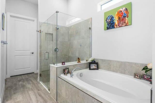 full bathroom featuring a garden tub, wood finished floors, and a shower stall