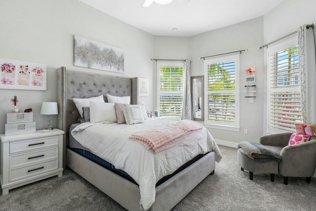 carpeted bedroom featuring baseboards and multiple windows