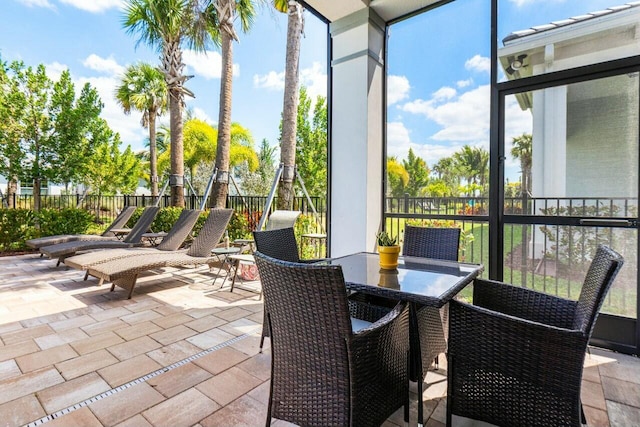 sunroom featuring a wall of windows and outdoor dining space