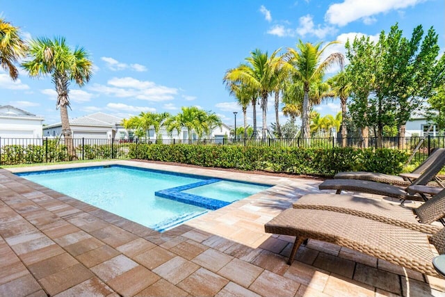view of swimming pool featuring a patio area, a pool with connected hot tub, and fence