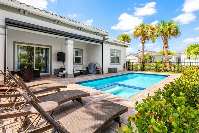 view of pool featuring fence, a patio area, and a pool with connected hot tub