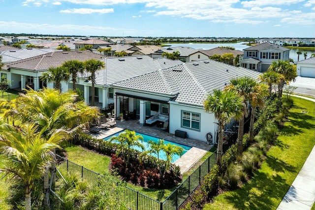 rear view of property with a residential view, a fenced backyard, and a tiled roof