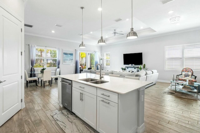 kitchen with dishwasher, a sink, visible vents, and light wood-type flooring