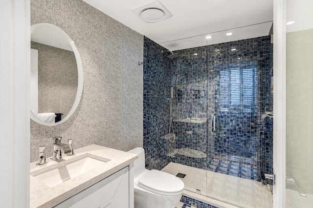 3740 S Ocean Blvd Unit 1205, Highland Beach, FL 33487 - bathroom with tile walls, a stall shower, vanity, and toilet