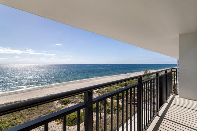 balcony featuring a beach view and a water view