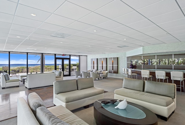 living room featuring expansive windows, recessed lighting, a paneled ceiling, and carpet