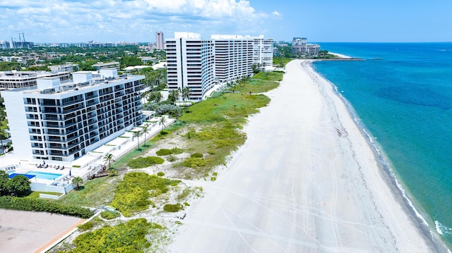 drone / aerial view featuring a beach view, a city view, and a water view