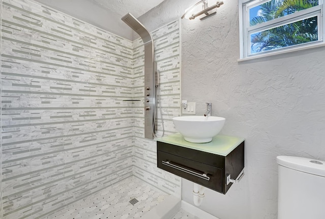 946 Paseo Morella, West Palm Beach, FL 33405 - full bathroom featuring a textured wall, tiled shower, vanity, and toilet